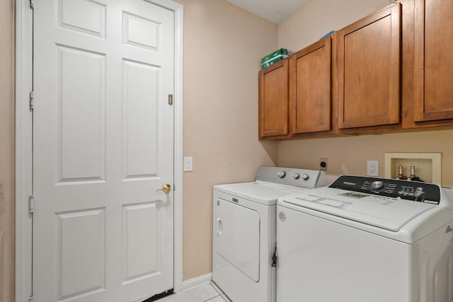 washroom featuring light tile patterned floors, separate washer and dryer, and cabinets