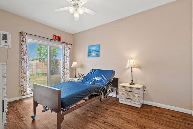 bedroom with ceiling fan, wood-type flooring, and a wall unit AC