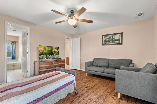 bedroom with light hardwood / wood-style floors, ceiling fan, and ensuite bathroom