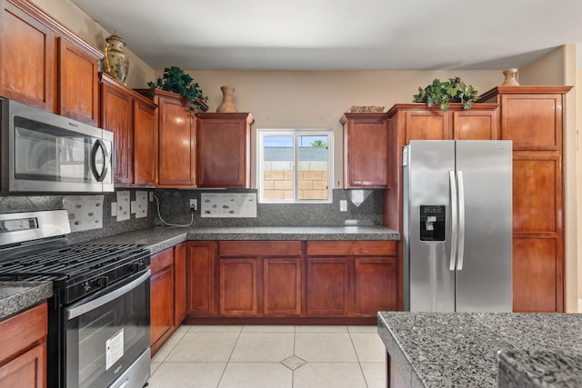 kitchen with tasteful backsplash, light tile patterned floors, and stainless steel appliances