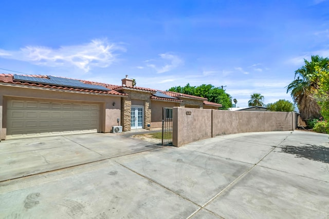 view of front of house featuring a garage and solar panels