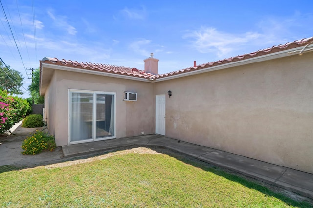 back of house featuring a lawn and an AC wall unit