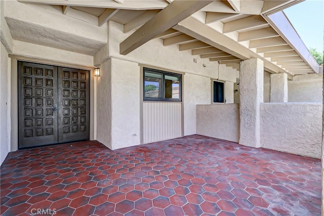 view of exterior entry with a patio area