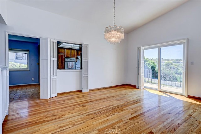 interior space featuring vaulted ceiling, a chandelier, and light hardwood / wood-style floors