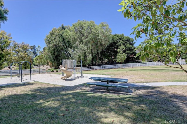 view of property's community featuring a lawn and a playground