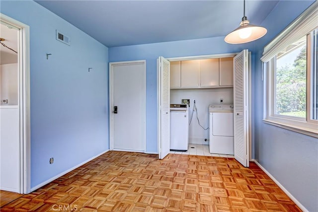 washroom with cabinets, separate washer and dryer, and light parquet flooring