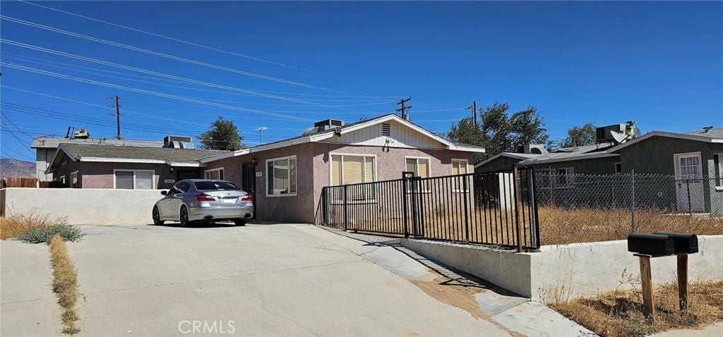 view of front of house featuring fence and stucco siding