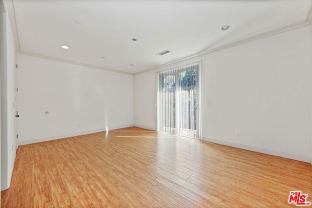 unfurnished room featuring light wood-type flooring and crown molding