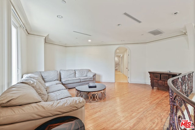 living room featuring ornamental molding and light wood-type flooring