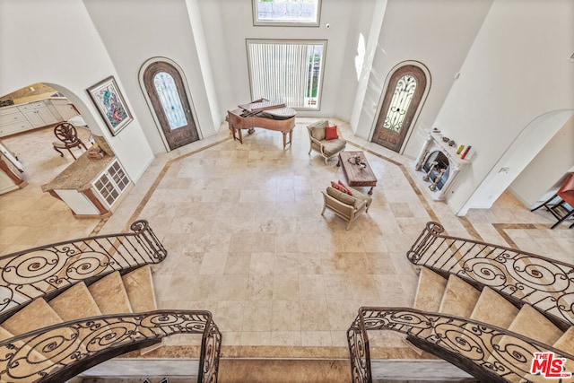 entrance foyer featuring a high ceiling and a fireplace