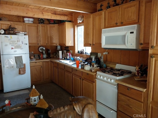 kitchen with beamed ceiling, wood ceiling, sink, and white appliances