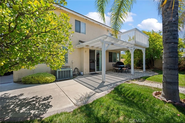 back of property with stucco siding, a lawn, a patio area, central AC, and a pergola