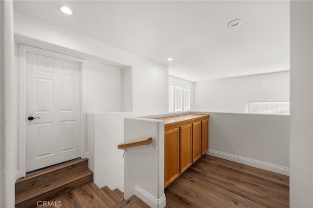 bar featuring baseboards, dark wood finished floors, and recessed lighting