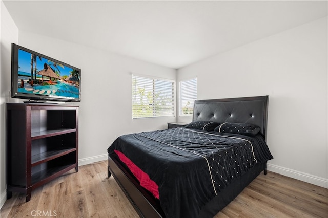 bedroom featuring wood finished floors and baseboards