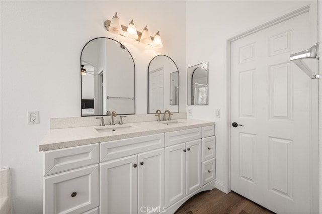 full bath featuring wood finished floors, a sink, and double vanity