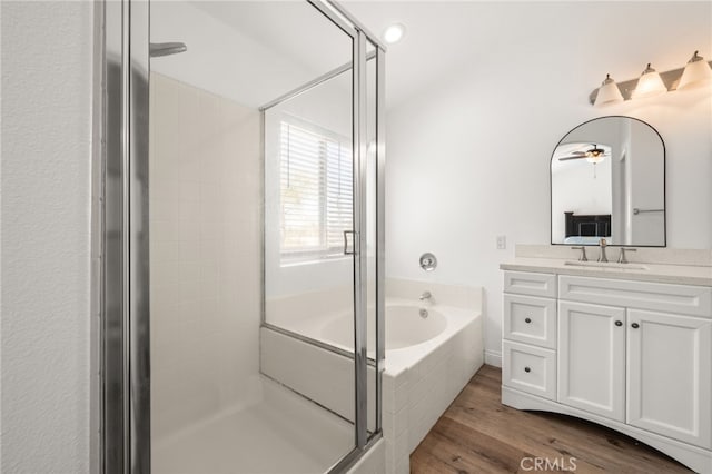 bathroom with a bath, a shower stall, wood finished floors, and vanity