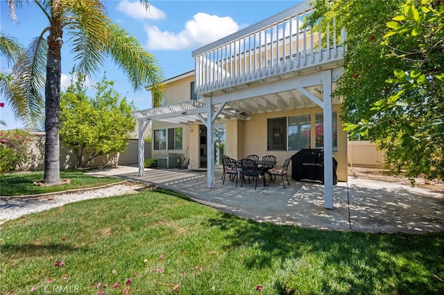 rear view of house featuring central air condition unit, fence, a lawn, stucco siding, and a pergola