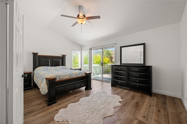 bedroom with lofted ceiling, access to outside, wood finished floors, and baseboards