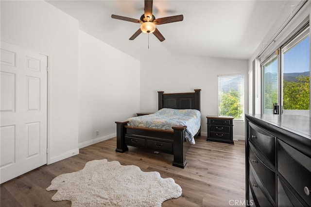 bedroom with vaulted ceiling, dark wood-style flooring, and baseboards