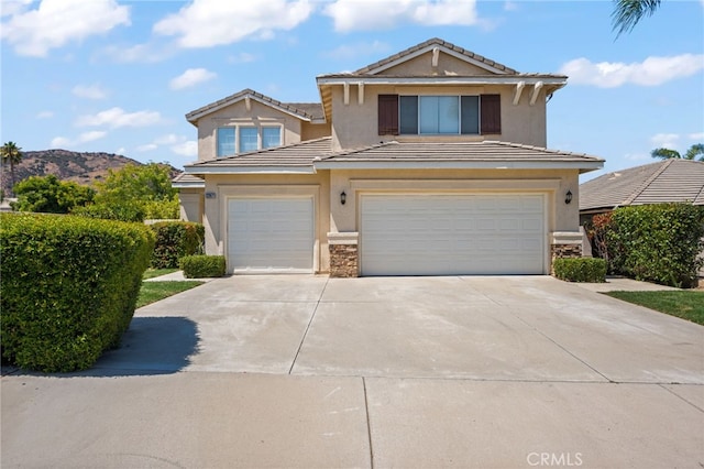 front of property with a garage and a mountain view