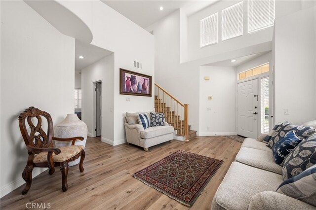 living room featuring a high ceiling and light hardwood / wood-style floors