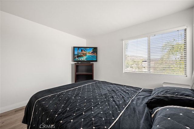 bedroom with baseboards and wood finished floors