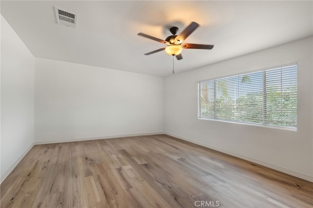 unfurnished room featuring light wood-style flooring, visible vents, ceiling fan, and baseboards