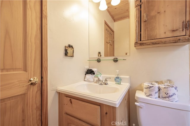 bathroom featuring wooden ceiling, vanity, and toilet