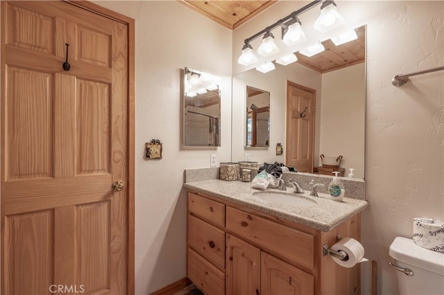 bathroom with wood ceiling, vanity, and toilet