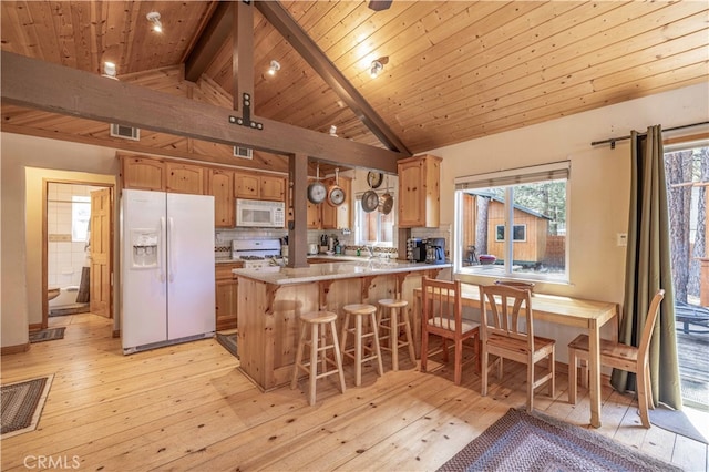 kitchen with light wood-type flooring, beam ceiling, kitchen peninsula, and white appliances