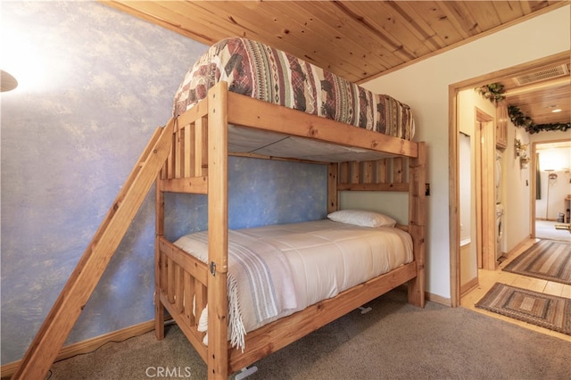 carpeted bedroom with wood ceiling