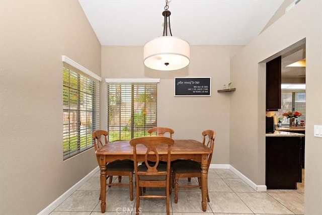 dining space featuring light tile patterned flooring and baseboards