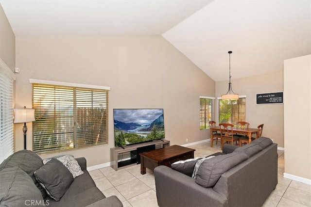 living room with a healthy amount of sunlight, light tile patterned floors, and high vaulted ceiling