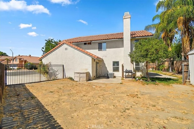 back of property with a tiled roof, a patio area, fence, and stucco siding