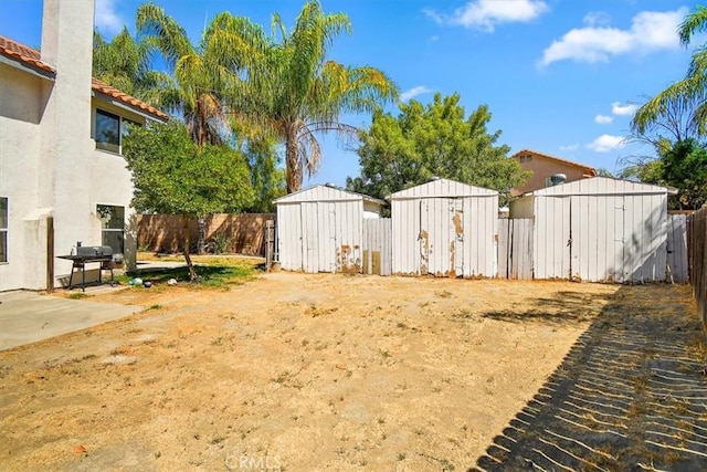 view of yard with a storage shed, fence, and an outdoor structure