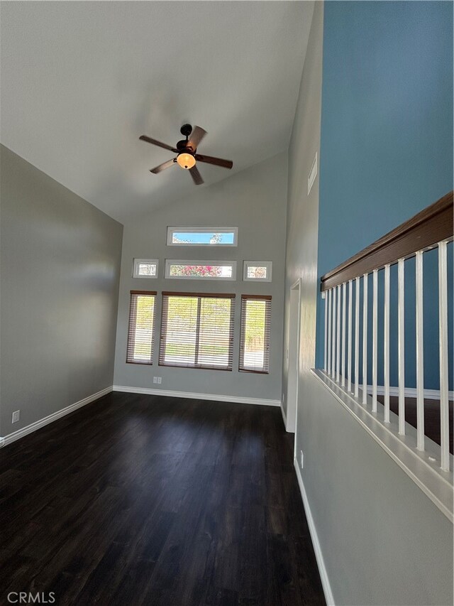 unfurnished living room featuring vaulted ceiling, dark hardwood / wood-style floors, and ceiling fan