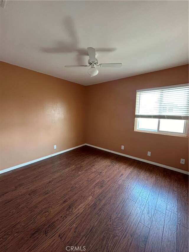 spare room with ceiling fan and dark hardwood / wood-style flooring