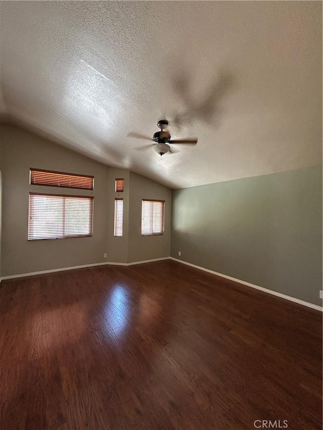 spare room featuring a textured ceiling, lofted ceiling, dark hardwood / wood-style floors, and ceiling fan