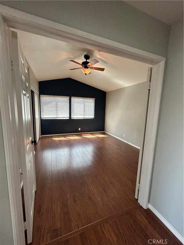 unfurnished room with ceiling fan, lofted ceiling, and dark wood-type flooring