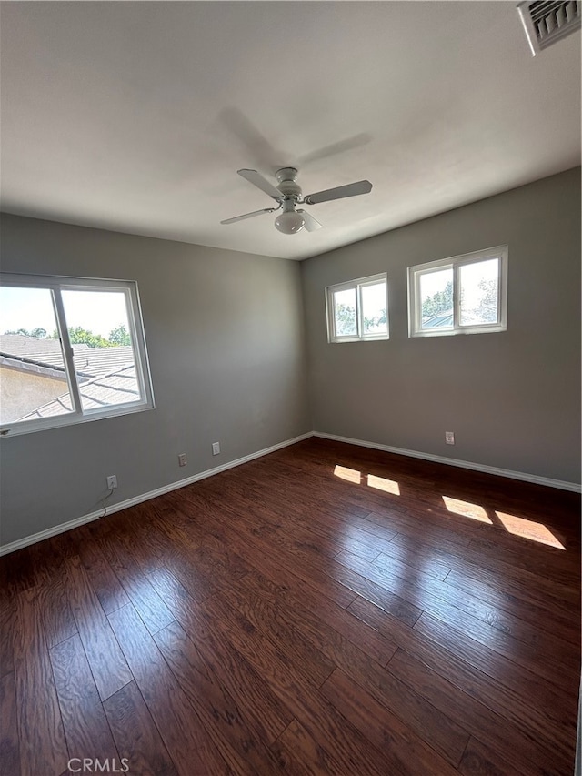 spare room featuring dark wood-type flooring and ceiling fan