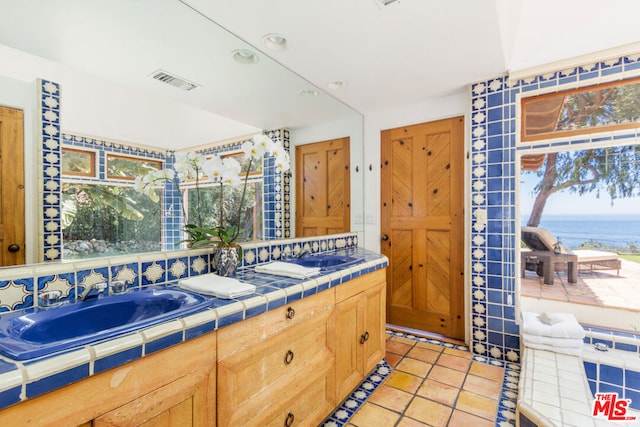 bathroom with vanity, tile patterned floors, and a water view