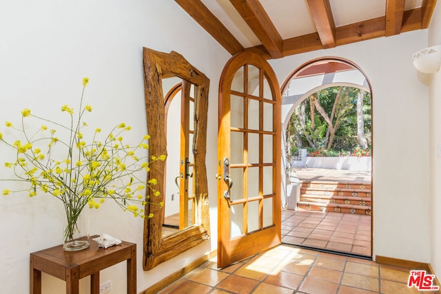 doorway to outside featuring beam ceiling and light tile patterned floors