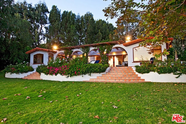 mediterranean / spanish-style house with a front lawn