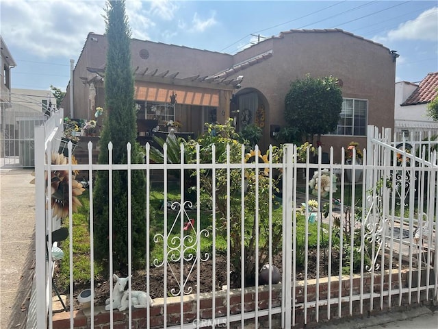 view of front of home with stucco siding, fence, and a pergola