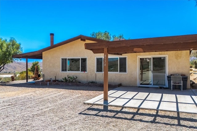 back of house with a patio and a mountain view