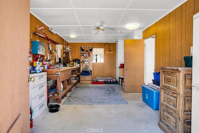 miscellaneous room with ceiling fan, wood walls, and a workshop area