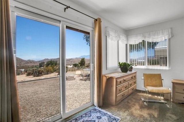 doorway with dark colored carpet and a mountain view