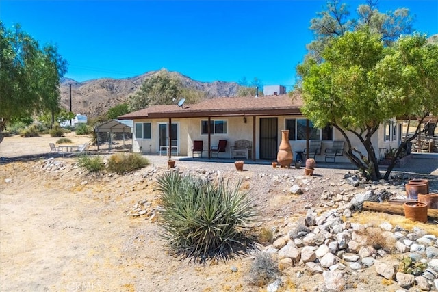 view of front of property with a patio and a mountain view