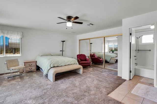 tiled bedroom featuring connected bathroom, a closet, and ceiling fan