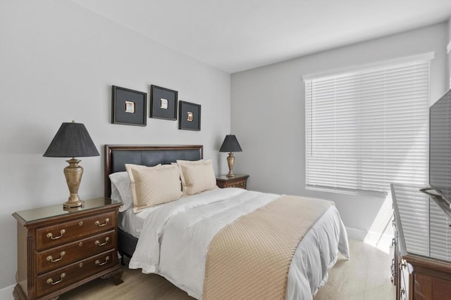 bedroom featuring multiple windows and light hardwood / wood-style flooring